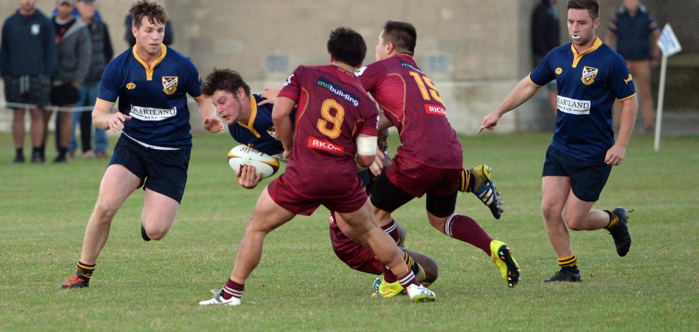 Loose forward Jamie Mowat runs the ball up for Dunedin with Caleb Young (left) and Angus Vincent in support as Alhambra-Union players Caleb Gray (No9) and Conner van Turnhout try to stop him during a Dunedin premier club rugby match at Kettle Park yesterd