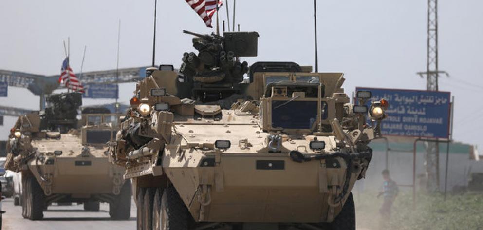 US military vehicles travel in the northeastern city of Qamishli, Syria. Photo: Reuters