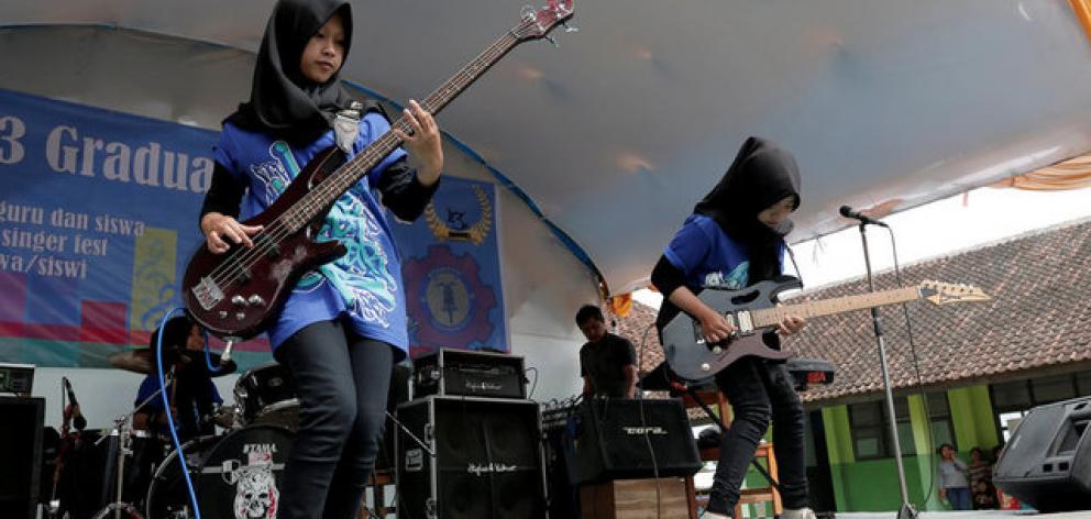 Widi Rahmawati and Firdda Kurnia, members of the metal Hijab band Voice of Baceprot, perform during a school's farewell event in Garut, Indonesia. Photo: Reuters Widi Rahmawati and Firdda Kurnia, members of the metal Hijab band Voice of Baceprot, perform during a school's farewell event in Garut, Indonesia. Photo: Reuters