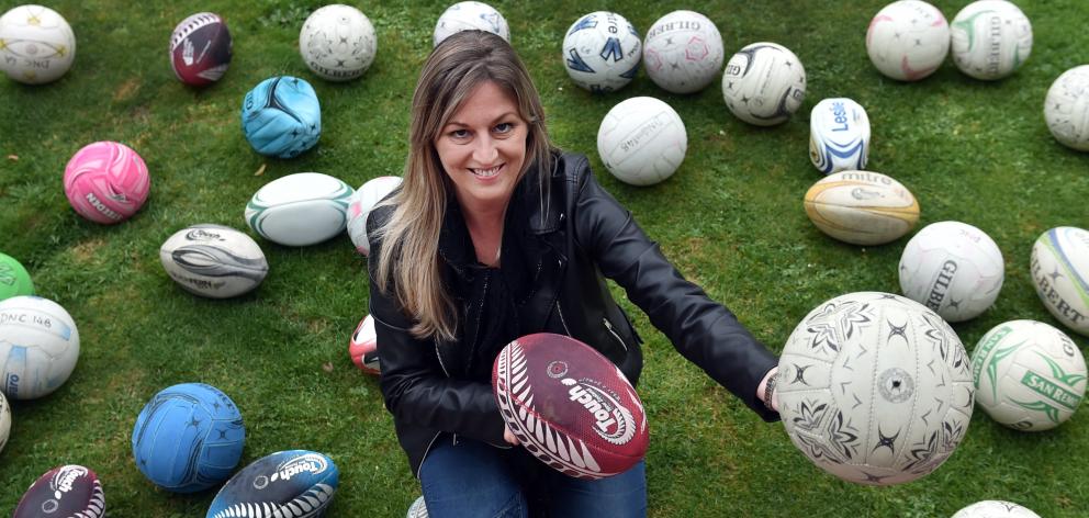 Otago Polytechnic student Carla Hore displays part of a donated collection of used sports balls....