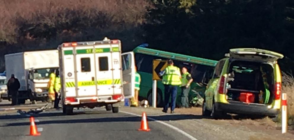 Emergency services attend a collision between a tourist bus and a truck on State Highway 8, near Roxburgh Dam. Photo: Jono Edwards