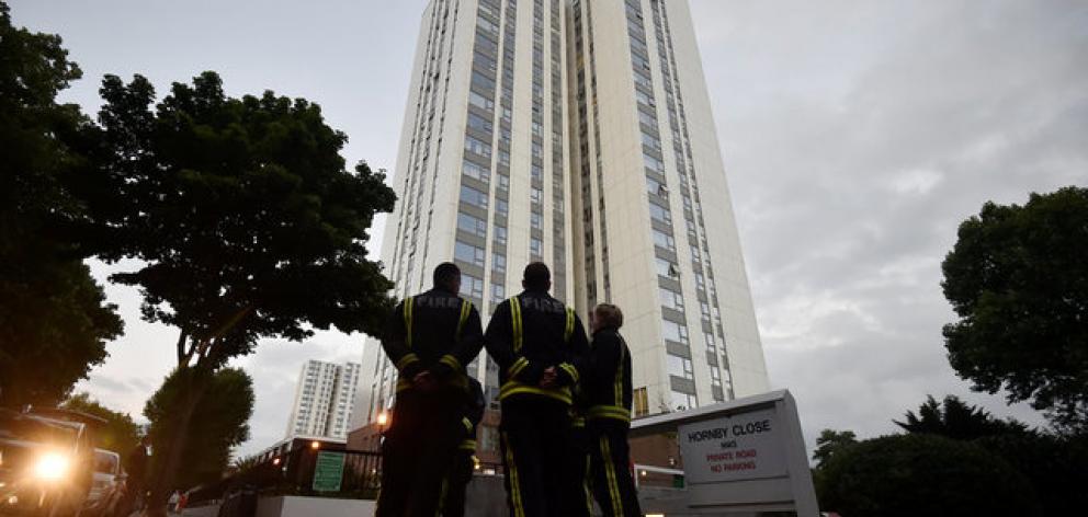 Firefighters stand outside the Burnham Tower residential block, as residents were evacuated as a precautionary measure. Photo: Reuters Firefighters stand outside the Burnham Tower residential block, as residents were evacuated as a precautionary measure. Photo: Reuters