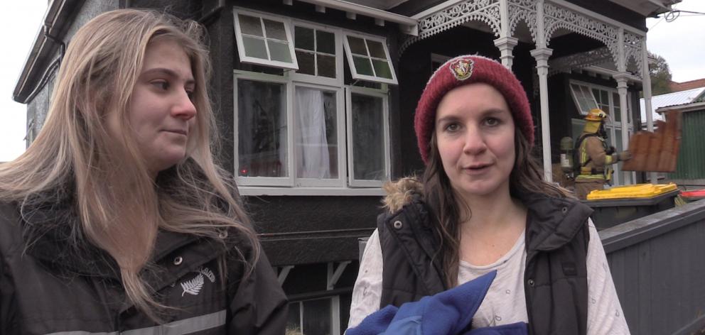 Emily Rhoades (19), of Christchurch, and Clare McInerney-Heather (19), of Otaki, wait in Park St, North Dunedin, yesterday morning, while firefighters deal with a fire in their flat. Photo: Gerard O'Brien