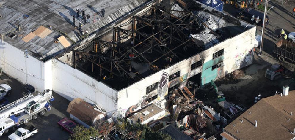 Firefighters work inside the burned warehouse following the fatal fire in the Fruitvale district of Oakland. Photo: Reuters