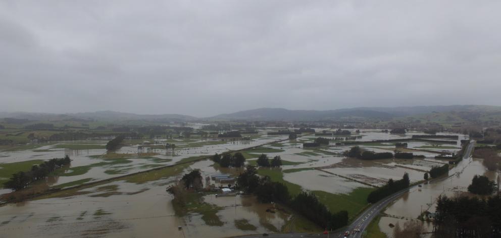 An aerial view shows water from the flooded Tokomairaro River spreading over the plains south of...