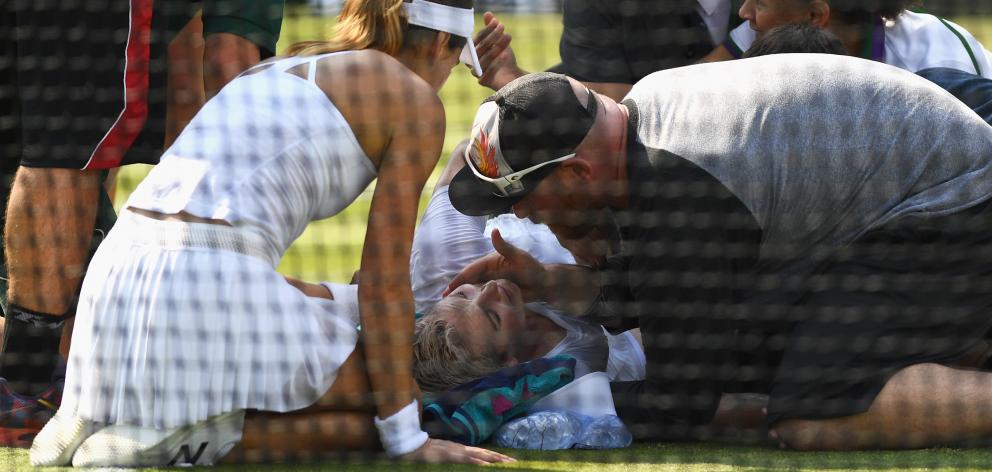 American Bethanie Mattek-Sands receives treatment from the medical team and later retires from the Ladies Singles second round match against Sorana Cirstea (left).