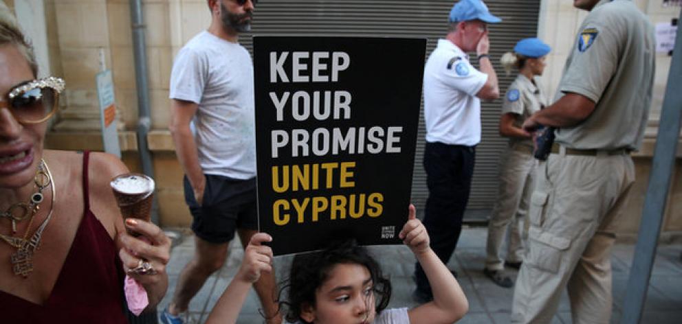 A girl holds a placard during a demonstration in favour of a peace settlement between Greek and Turkish Cypriots on divided Cyprus. Photo: Reuters