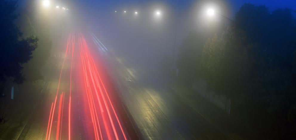 In the clouds, rain next? . . . 8 O'Clock starters travel through heavy fog on Stuart street in Dunedin as seen from the Highgate bridge. Photo: Stephen Jaquiery