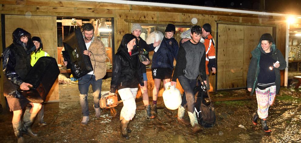 Josh Adam carries a gas bottle from his Henley sheep, beef and dairy farm with wife Ellie-May...