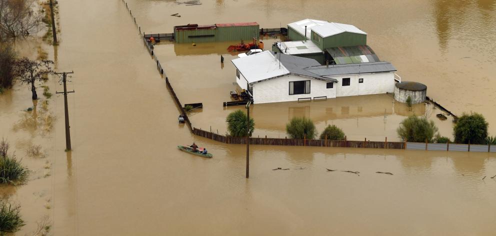 Henley residents Nigel Hillis and his daughter Courtney canoe through the town, checking on...