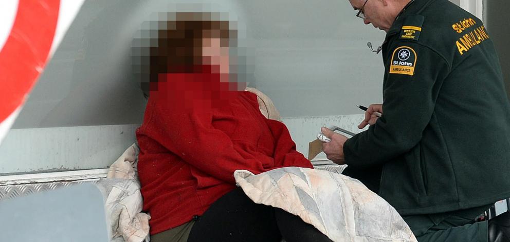 A St John staff member talks to a woman who suffered a medical event in South Dunedin yesterday...