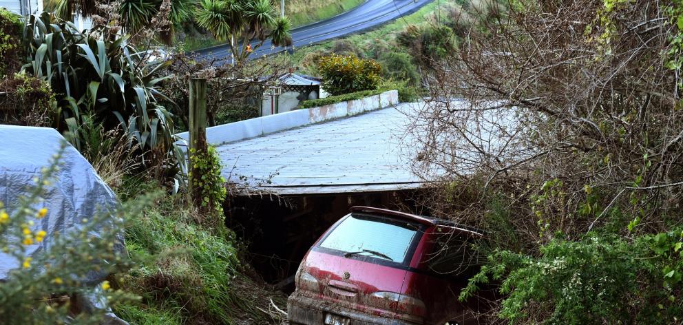 A car shunted downhill during the Ravenswood Rd slip came to rest in the garage at the rear of a...