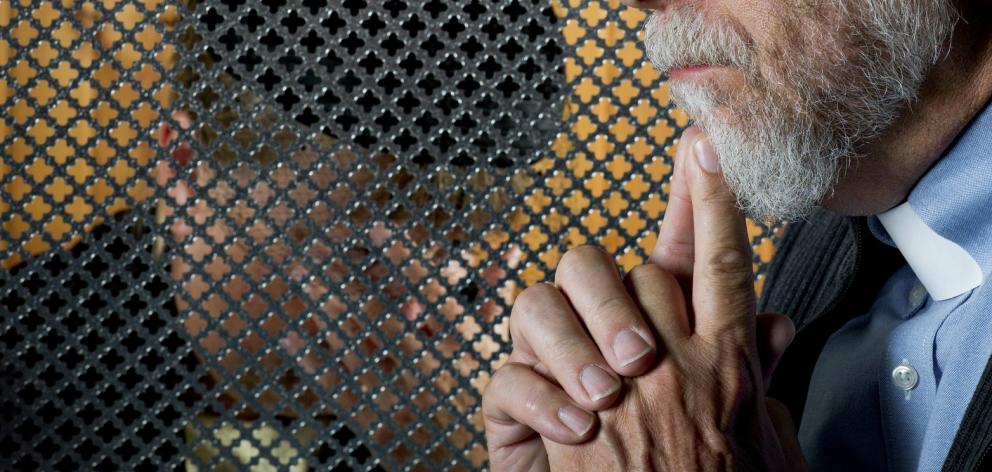 A patron giving a confession through a grate. Photo: Getty Images