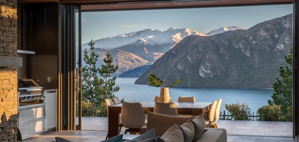 The covered outdoor room faces the lake but can be sheltered from the wind by stacking doors that...