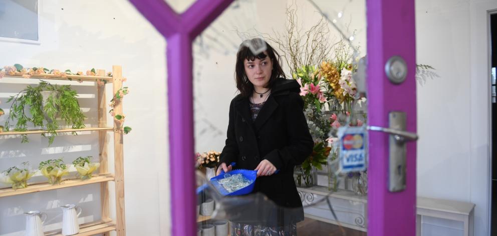 Netta Truell cleans up after a window in the front door of Flowers on Mornington was smashed, so...
