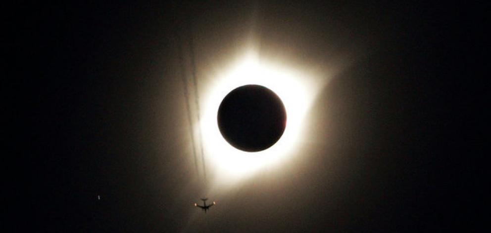 A jet plane flies by the total solar eclipse in Guernsey, Wyoming. Photo: Reuters