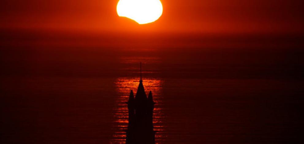The Saint-They Chapel is seen in silhouette at sunset during a partial solar eclipse as the moon passes in front of the sun. Photo: Reuters