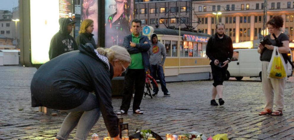 A woman puts candle at the Market Square where several people were stabbed, in Turku. Photo: Reuters A woman puts candle at the Market Square where several people were stabbed, in Turku. Photo: Reuters