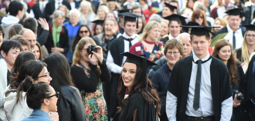 Lucy Birks (centre, 22) from Morrinsville, graduating  with a BA, reacts to friends lining the...