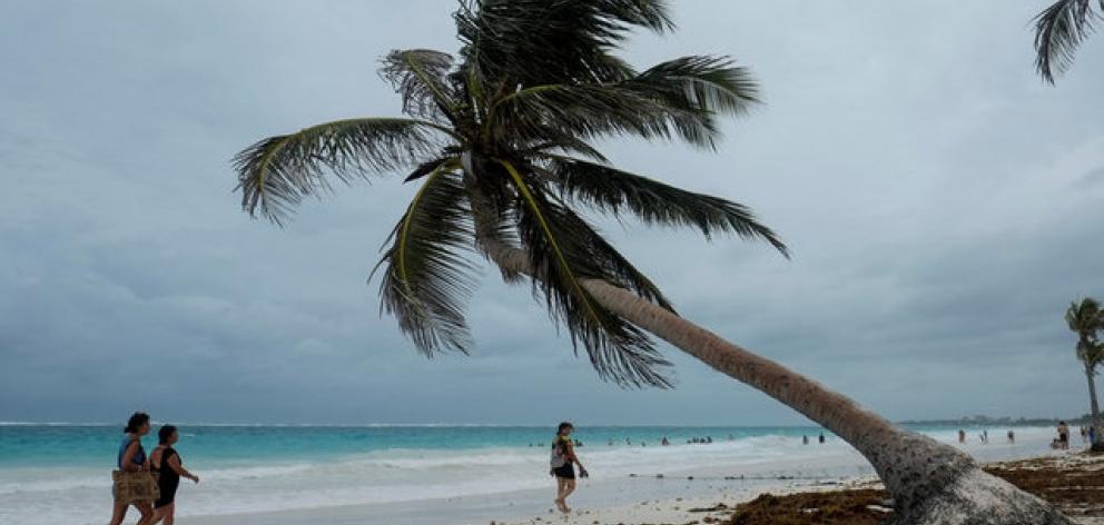 Tourists walk along a beach with heavy clouds caused by the proximity of tropical storm Franklin that is near the coast of Quintana Roo, Mexico. Photo: Reuters Tourists walk along a beach with heavy clouds caused by the proximity of tropical storm Franklin that is near the coast of Quintana Roo, Mexico. Photo: Reuters