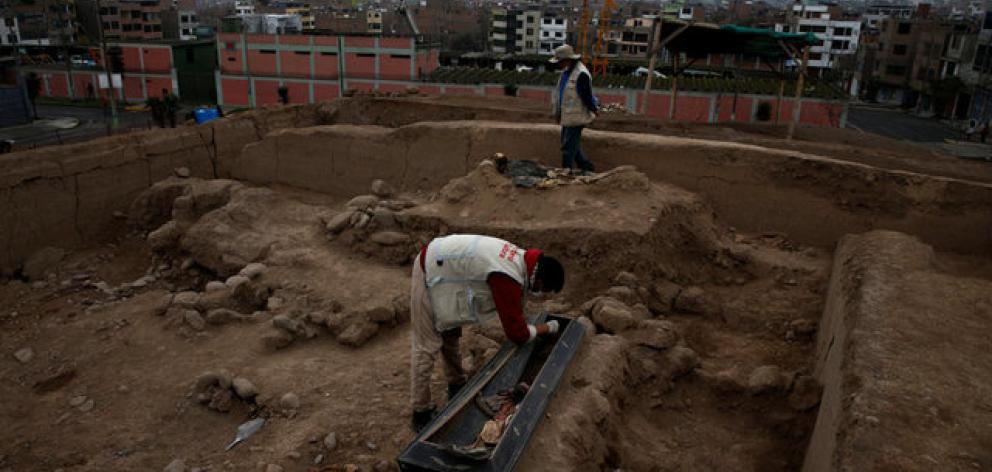 Archaeologist works at a tomb of one of sixteen Chinese migrants, discovered buried at the turn of the 20th century in the pre-colombian pyramid of Bellavista in Lima. Photo: Reuters Archaeologist works at a tomb of one of sixteen Chinese migrants, discovered buried at the turn of the 20th century in the pre-colombian pyramid of Bellavista in Lima. Photo: Reuters