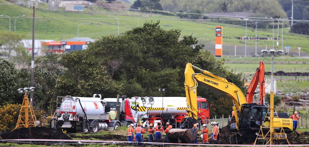 New Zealand Refinery staff at the site of a fuel pipeline leak on farm land between State Highway...