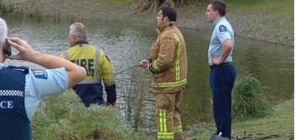 Police and rescuers at Westlake Dr reserve in Christchurch where two people are missing after a car drove into a lake. Photo / Broadcast Media