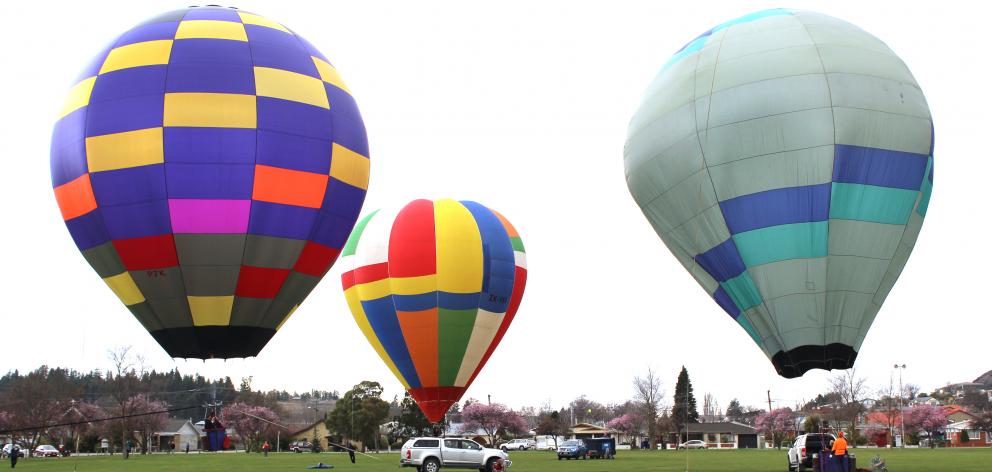Hot air balloons hover above Alexandra's Pioneer Park yesterday. Photo: Jono Edwards