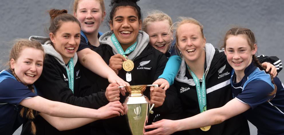 Members of the St Hilda’s Collegiate under-15 rugby team share the spoils — the Women’s World Cup trophy — with a trio of Black Ferns at Hancock Park in Dunedin  yesterday. From left are Katie Wilson (13), Selica Winiata, Anna Harcus (14), Victoria Subrit