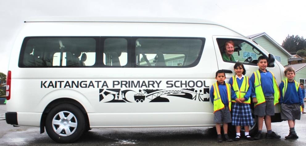 Kaitangata Primary School pupils (from left) Martin (5), Jess (7) and Freddy Daumann (8) with Evan Anderson (6) and school principal Anneta Payne (driver window) have a reason to celebrate now the school has its own minibus to transport pupils. Photo: Sam