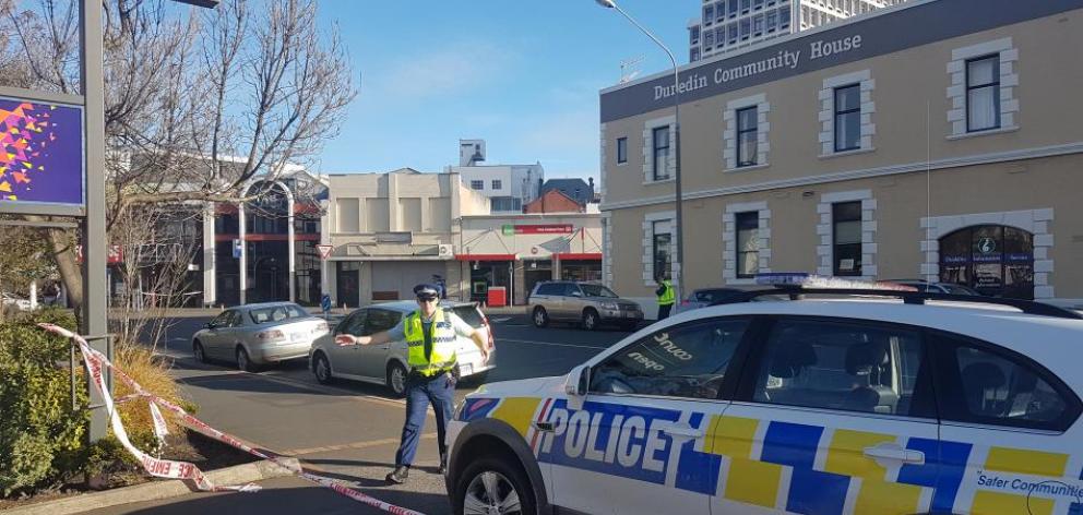 A Dunedin police officer asking people that get back from the cordon at Moray Pl. Photo: ODT
