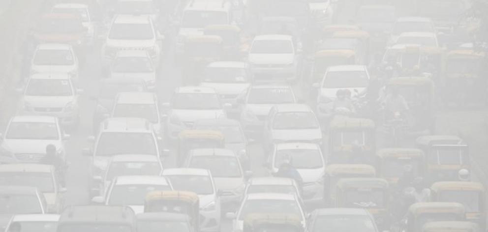 Vehicles drive through heavy smog in Delhi. Photo: Reuters