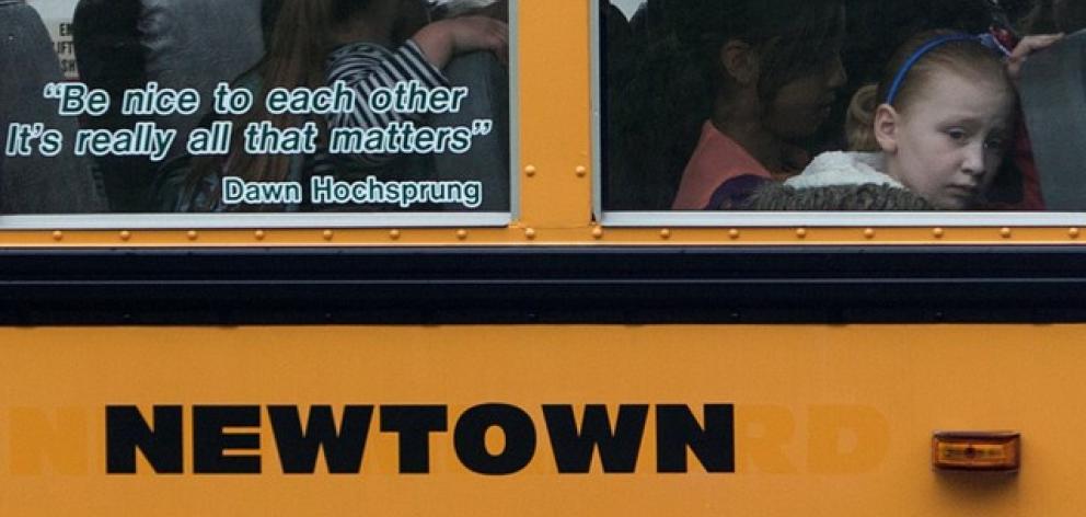 A quote by slain Sandy Hook Elementary School principal Hochsprung is displayed on window of a school bus in Newtown. Photo: Reuters