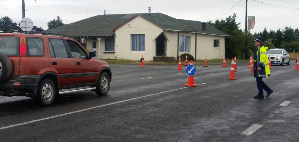 Police directing northbound traffic on to Glenavy-Tiwai Rd at Glenarm about 1km from the crash site. Photo: Hamish MacLean