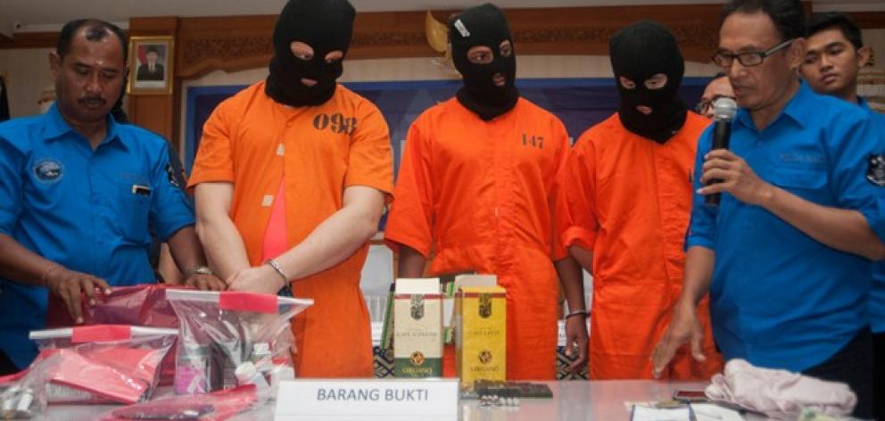 Anti-Narcotics Agency officials show an Australian man, an American man, and a Malaysian man to reporters after they were arrested for carrying illegal drugs. Photo: Antara Foto/Nyoman Budhiana via Reuters