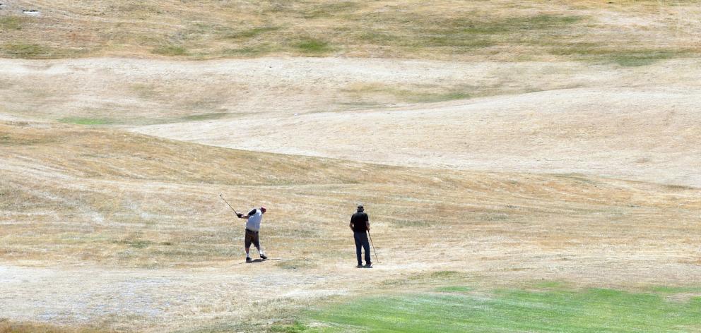 Golfers play on a dry Chisholm Links course yesterday after a long period of fine weather in...