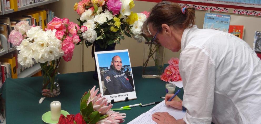 Palmerston woman Nell Collyer signs a condolence book at the East Otago High School library...