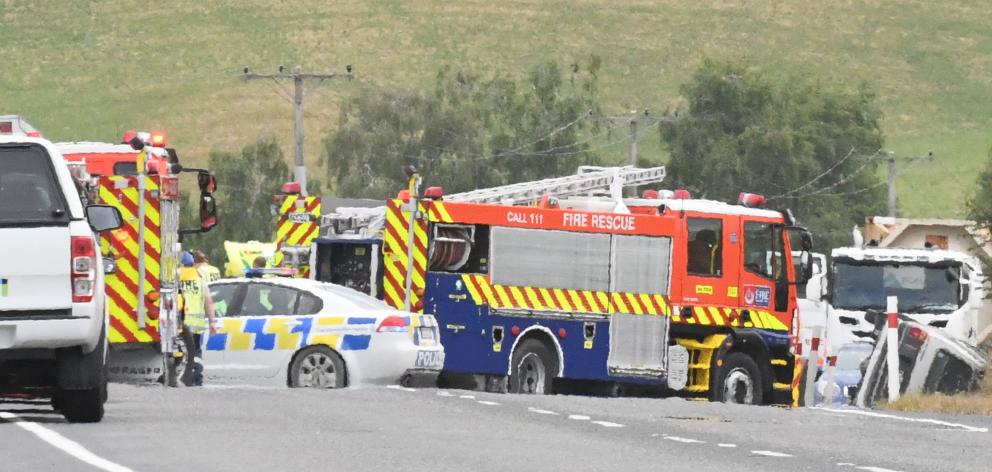 Emergency services work at the scene of a collision between a van and a truck on State Highway 1,...