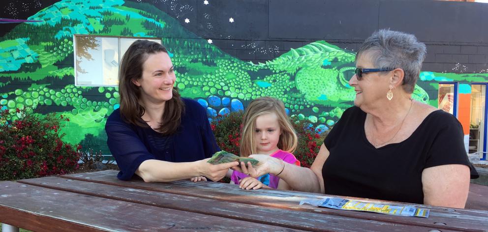Taieri Times 10 co-ordinator Elizabeth Dalton (left), watched by her daughter, Esme Dalton (4), receives $330 from pensioner Gaynor Robson in Mosgiel on Friday. Photo: Shawn McAvinue
