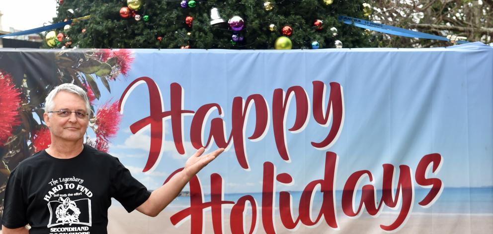 Hard to Find Bookshop owner Warwick Jordan wants to change the ``Happy Holidays'' sign around the Octagon Christmas tree. Photo: Peter McIntosh
