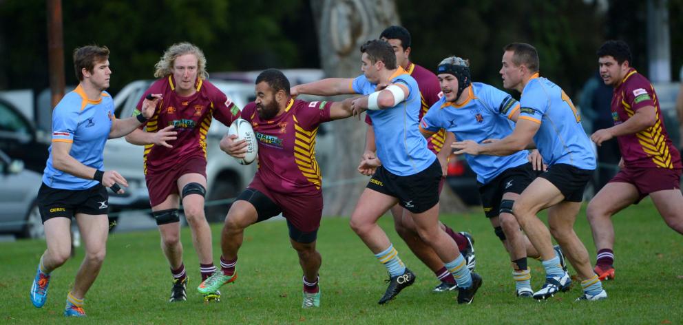 Alhambra Union wing Peni Qauqau - Dodds fends off University A halfback Dan Crowley during a...
