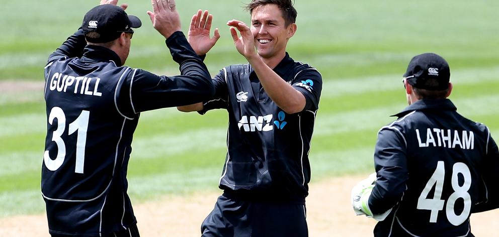 New Zealand paceman Trent Boult (centre)  is congratulated by team-mates Martin Guptill (left)...