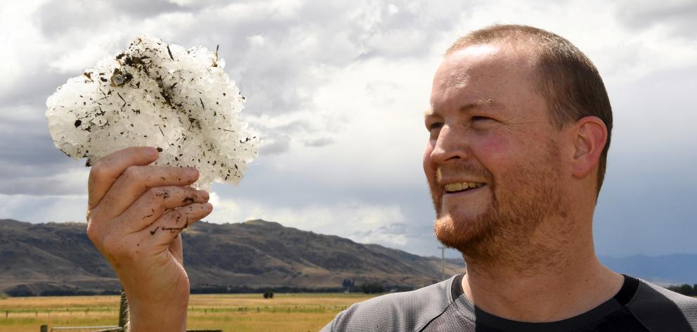 Ryan Drury yesterday holds a hunk of compacted hail  which fell on his Ida Valley home on...