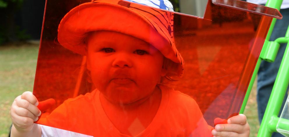 Millie Walters (19 months) has fun with a red filter and other pieces of science-themed...