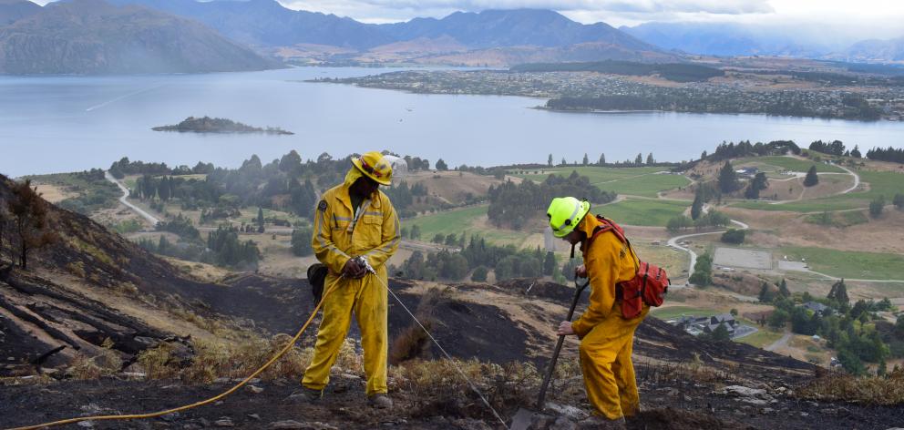 Gore Volunteer Fire Brigade officers Joe Natuikata (left) and Johnathon Moate dig up and...