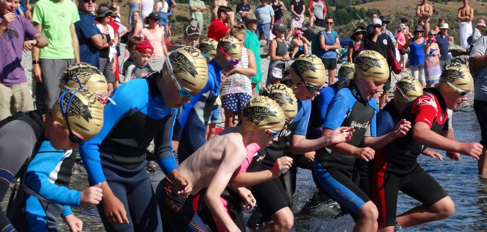 The starting gun sounds and  about 20 children sprint into the water at the start of the Little...