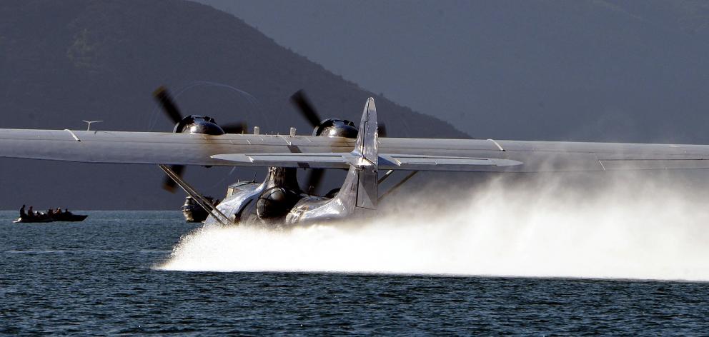 A Catalina flying boat, which will return this year, hurtles towards boats on Lake Wanaka as it...