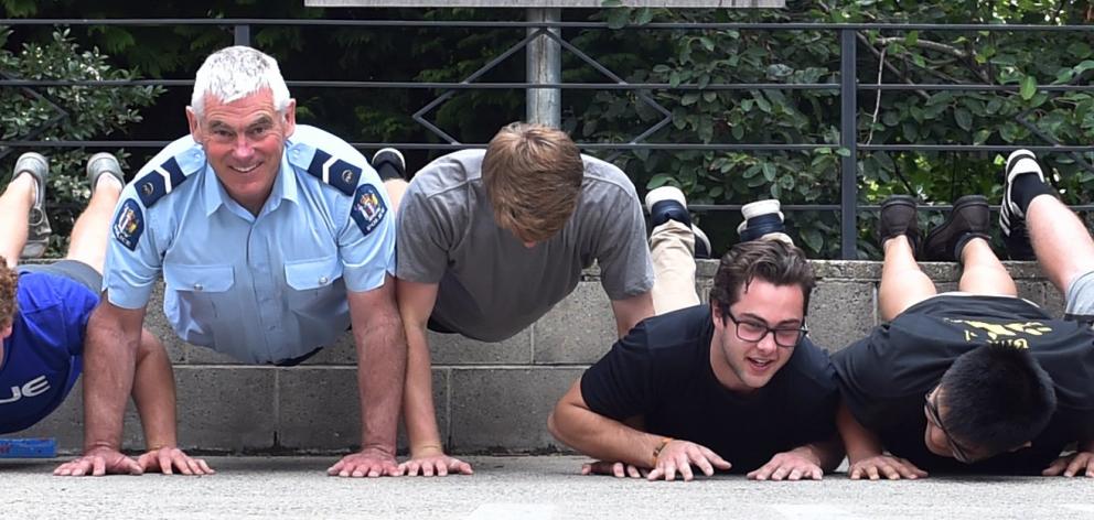 Campus cop Senior Constable John Woodhouse tests his brawn against first-year students at University College yesterday. The policeman challenged residents of the college to a press-up competition, and won, stopping at 60. The closest any of the 14 competi
