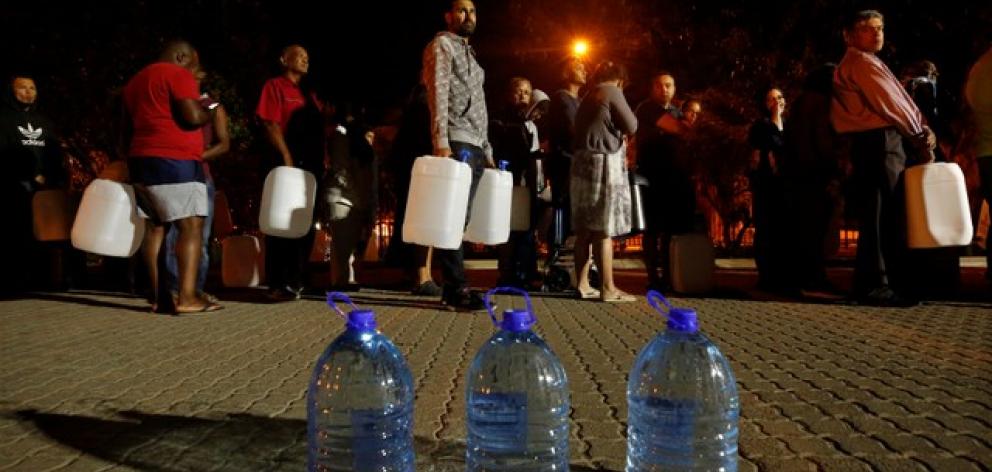 People queue to collect water as fears over the city's water crisis grow in Cape Town. Photo:...