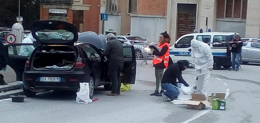 Forensics inspect a car used by a gunman in Macerata. Photo: Reuters